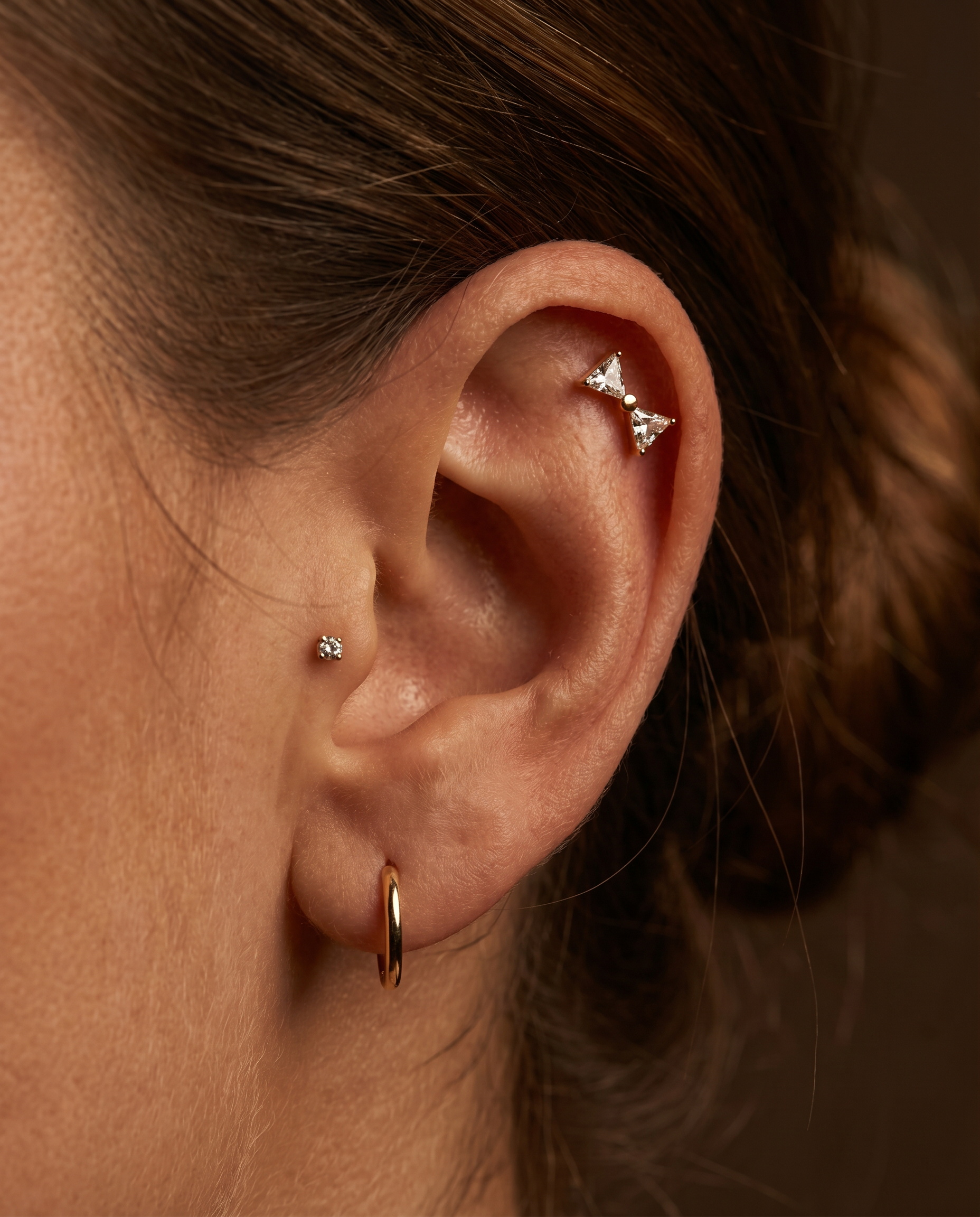 Mira dobbelttrekant-piercing i guld paa oere - helix flat back