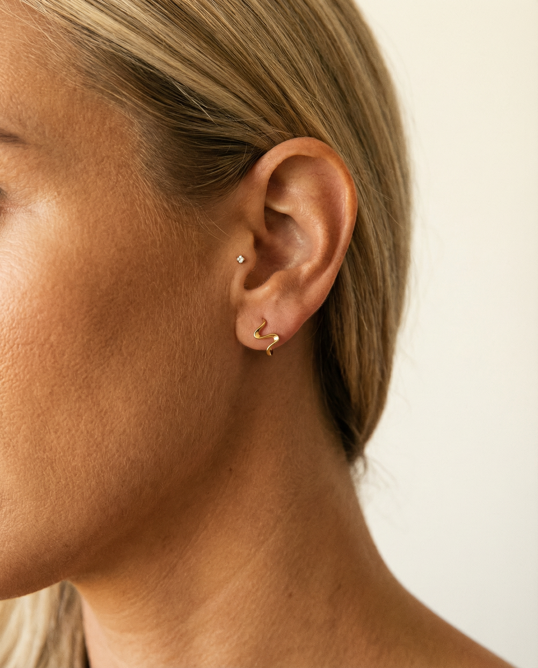 Inara Hoops med Flydende Former i guld — close-up dagslys
