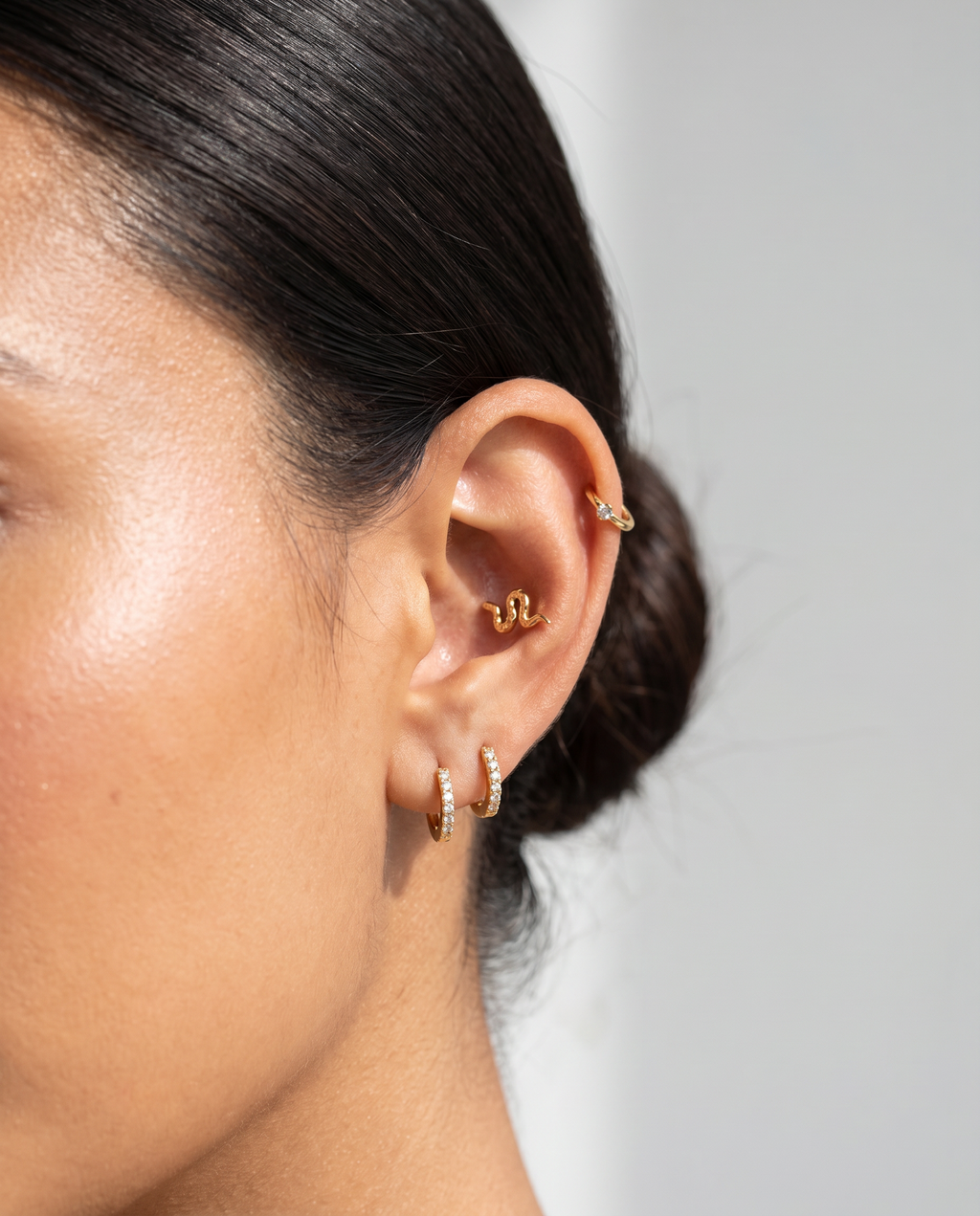 Nina sølvbelagt slange piercing i guld paa oere - helix flat back piercing