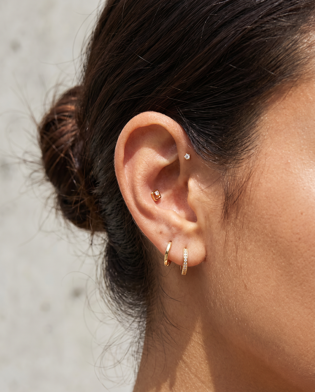 Rudeformet flatback piercing med zirkon i guld paa oere - helix flat back piercing